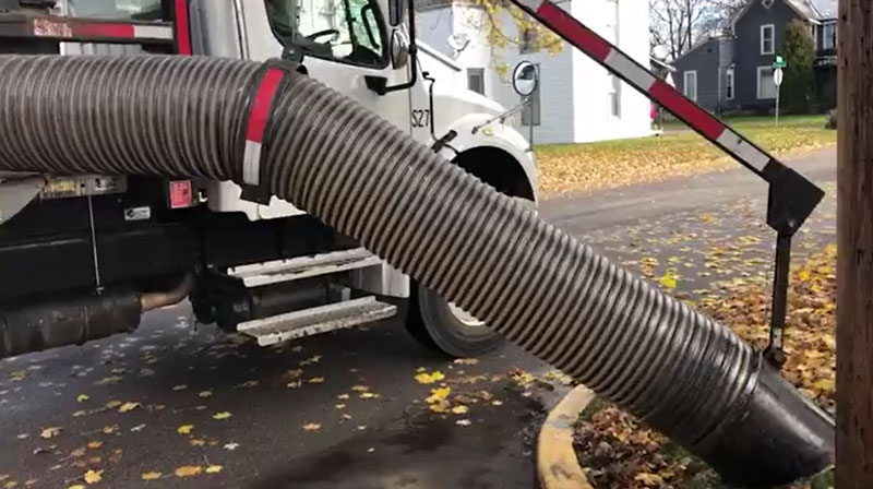 A vac truck collects a pile of leaves