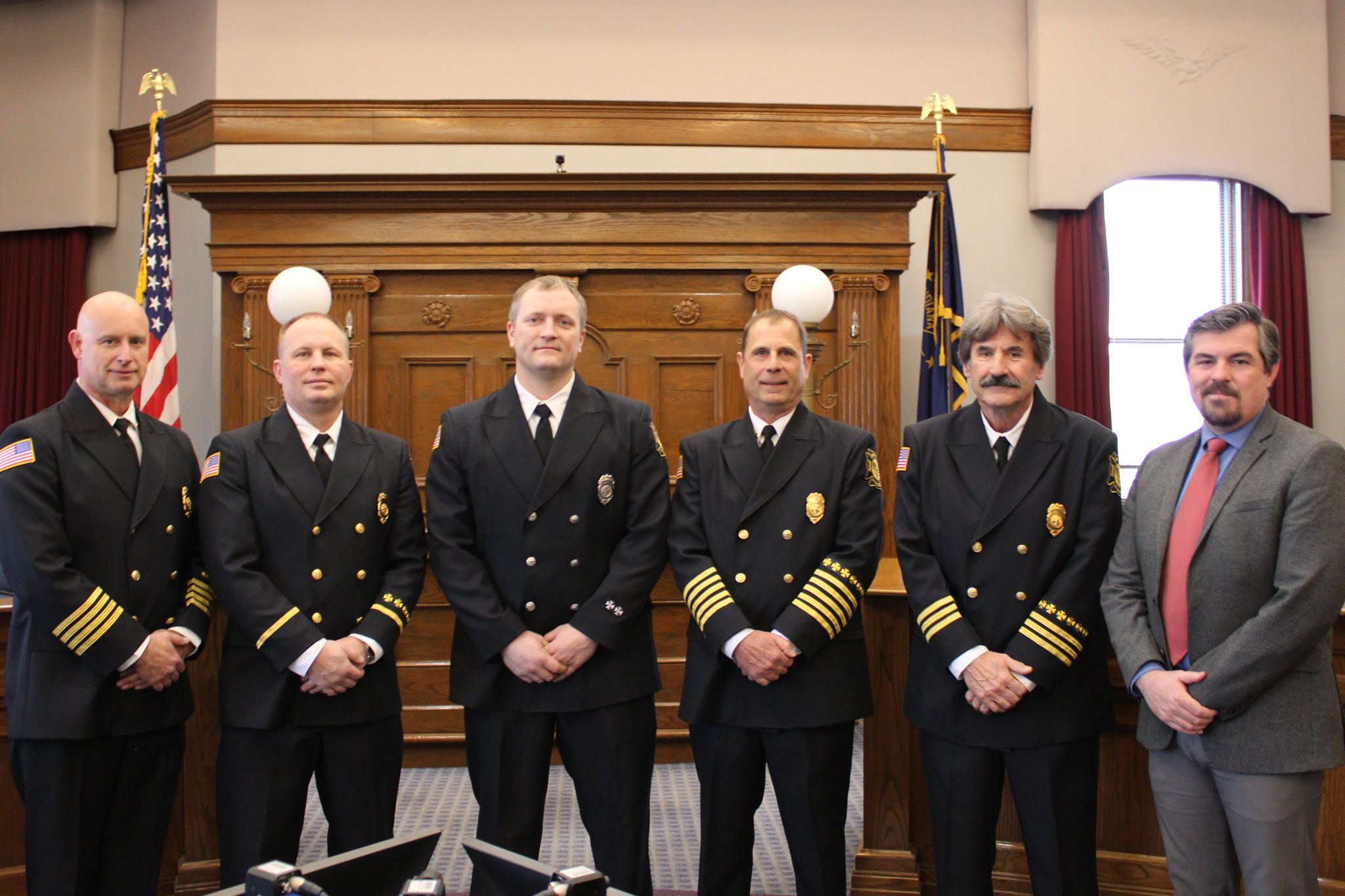 Five uniformed members of the Huntington Fire Department pose in a line with Mayor Richard Strick